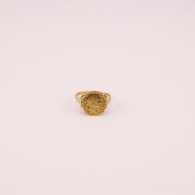 gros plan d'une bague en or sur une surface blanche