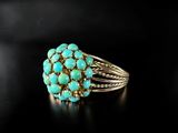 a close up of a turquoise stone ring on a black surface