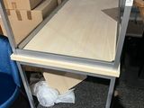 une table avec une étagère et une chaise dans une pièce