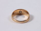 a close up of a gold ring with a diamond on it