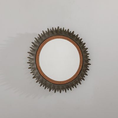 un miroir rond accroché au mur d'une pièce
