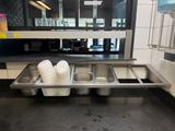 three sinks in the middle of the kitchen with dishes on them