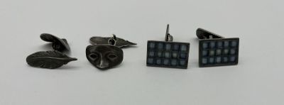 trois paires de boutons de manchette posées sur une table