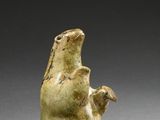 a close up of a sculpture of a bear holding a bird