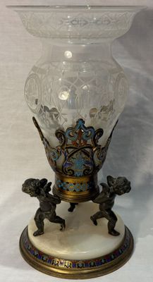 a glass vase with a statue on it on a table