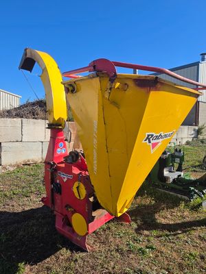 an image of a yellow and red machine in the grass