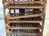 un casier à vin en bois sur lequel sont posées plusieurs bouteilles