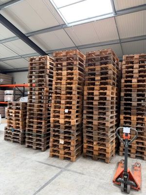 many pallets stacked up in a warehouse with a fork