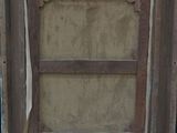 painting on easel in front of a black wall with a wooden frame
