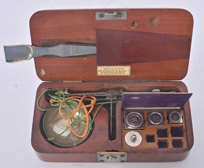 a wooden case with a pair of scissors and a magnifying glass in it