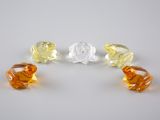 trois perles de verre de couleurs différentes posées sur une surface blanche