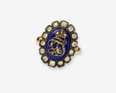 gros plan d'une bague en or avec une pierre bleue et des diamants