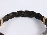 black braid leather bracelet with gold accents on a white surface