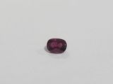 a purple sapphire stone on a white surface