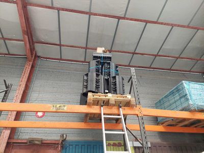 a fork lift in a warehouse with pallets on the floor