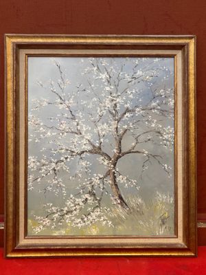 une peinture à l'huile représentant un arbre avec des fleurs blanches dans un cadre doré sur une surface rouge