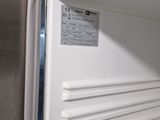 a white refrigerator that is open and has a label on the door