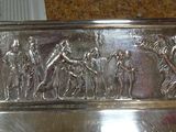 a silver plate with a picture of a group of people on it