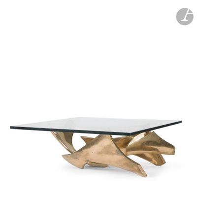 a gold coffee table with a glass top on a white background