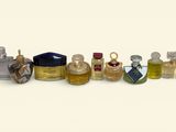 several bottles of perfume are lined up in a row on a white surface