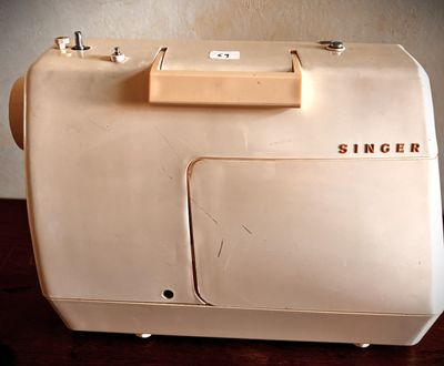 a white sewing machine sitting on a wooden table