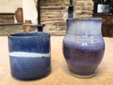 two vases sitting on a table next to each other