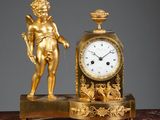 a gold clock sitting on top of a marble table