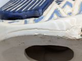 a close up of a blue and white shoe on a toilet