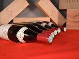 several bottles of wine are lined up on a red table cloth
