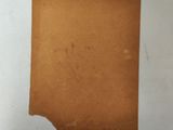 a close up of a piece of brown paper on a white surface