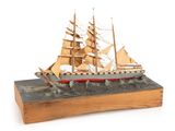 a wooden model of a ship on display on a table
