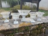 four white vases sitting on a stone wall