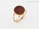 a close up of a gold ring with a coin on it