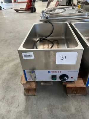 une photo montrant deux éviers en acier inoxydable posés sur des palettes dans un entrepôt