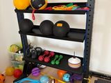 une photo d'un support pour matériel de gym avec des ballons et d'autres accessoires