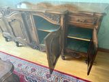 une armoire en bois dont la porte est ouverte, posée sur un parquet