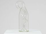 une sculpture en verre représentant une femme dans une bouteille en verre posée sur un socle