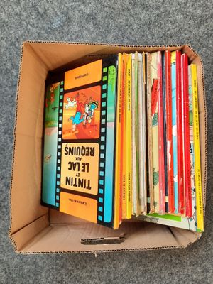 a box full of children ' s books sitting on top of a carpet