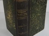an old book that is open on a white surface