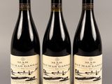 trois bouteilles de vin posées sur une table l'une à côté de l'autre
