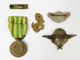 some medals and pins are laying on a white surface