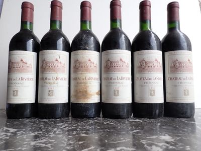 six bottles of red wine are lined up on a table