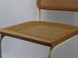 a chair that has a wicker seat on top of it