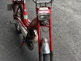 a red moped parked on the side of the road