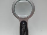 a magnifying glass on a white surface with a black handle