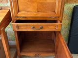 a wooden cabinet with a drawer on top of it