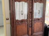 a large wooden armoire in a room with a checkered floor