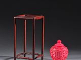 deux vases rouges et un petit vase rouge posés sur une table