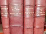 trois livres rouges sont empilés les uns sur les autres sur une étagère