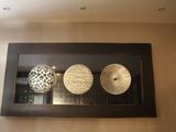 une photo d'une photo représentant trois objets décoratifs accrochés au mur